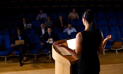 rear-view-female-business-executive-giving-speech_107420-63815