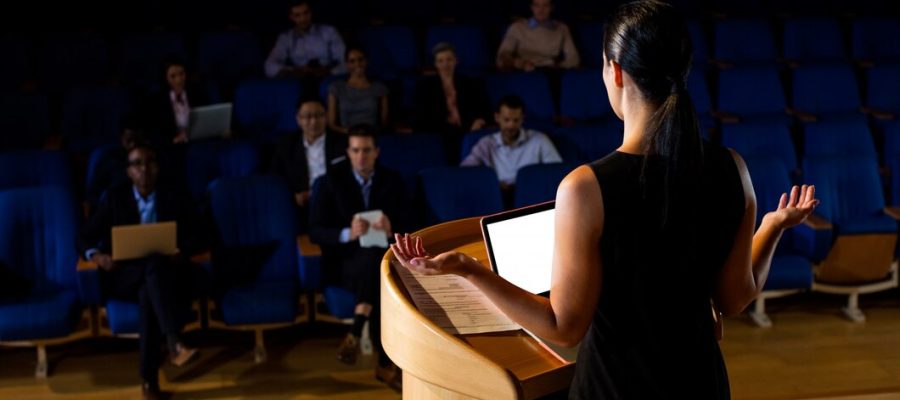 rear-view-female-business-executive-giving-speech_107420-63815